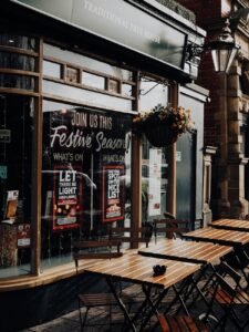 Charming street view of a traditional pub with outdoor seating, decorated for the festive season.